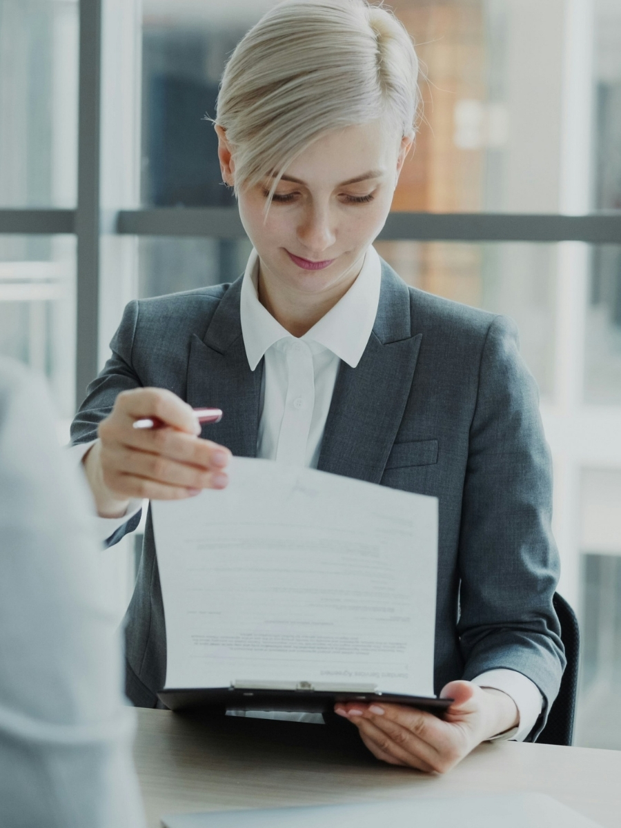 Femme en tailleur consultant un document professionnel